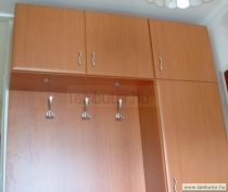 Előszobai beépített szekrény cseresznye laminált lapból, mellette a falon egy keretes tükör